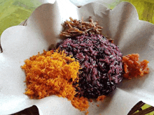 a close up of a plate of food with rice , vegetables , and sauce on a table .