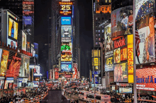 a busy city street at night with a kodak sign in the middle