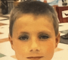 a close up of a young boy 's face with a few spots on it