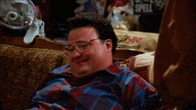 a man sits on a couch next to a sign that says " spell "