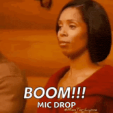 a woman in a red shirt is saying boom ! mic drop .