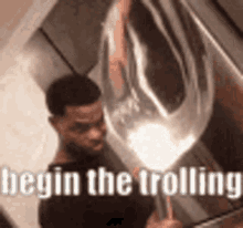 a man is holding a balloon in his hand with the words `` begin the trolling '' written above him .