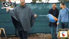 a man in a poncho holds a beach bag in front of a sign that says " beach bag "