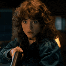a woman with curly hair and a denim jacket
