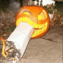 a pumpkin carved to look like a cigarette with a smile on its face