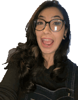 a woman wearing glasses and overalls is sticking out her tongue