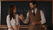 a man and a woman are standing in front of a blackboard with the word dog bark written on it