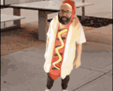 a bald man with a beard is dressed as a hot dog