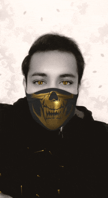 a man wearing a black and gold face mask with a skull on it