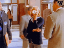 a group of people are standing in a hallway with a sign that says por 10 on it