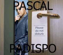 a man in a suit is behind a door with a please do not disturb sign