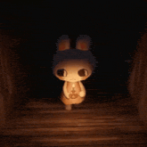 a stuffed bunny rabbit is holding a candle in a dark room .