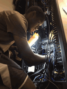 a man working on a computer with a light on and a sticker that says ' samsung ' on it