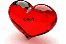 a red glass heart with the word amor written on it .