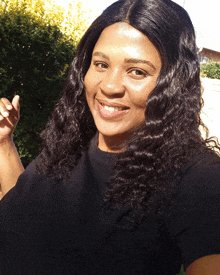 a woman wearing a black shirt that says ' calvin klein ' on it smiles for the camera