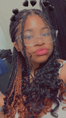 a girl wearing glasses and braids takes a picture of herself