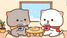 two cats are sitting at a table drinking coffee .