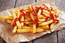 a pile of french fries with ketchup on top of them