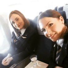 two female flight attendants are sitting on a plane