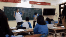 a group of students are in a classroom with a sign above them that says " chuyên môn sáng tạo "