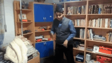 a man is dancing in front of a bookshelf that has a book titled ' chinese ' on the top shelf