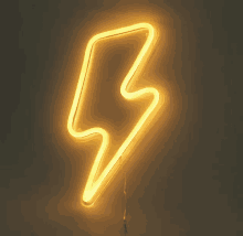 a yellow lightning bolt neon sign is lit up on a wall