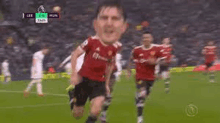 a soccer player with a big head is running on a soccer field with other players .