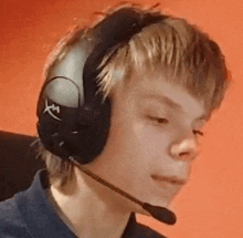 a young man wearing headphones with a microphone on his head .