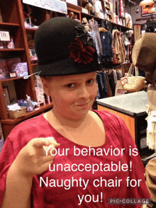 a young girl wearing a black hat with a red flower on it