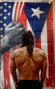 a man standing in front of an american flag and a puerto rican flag