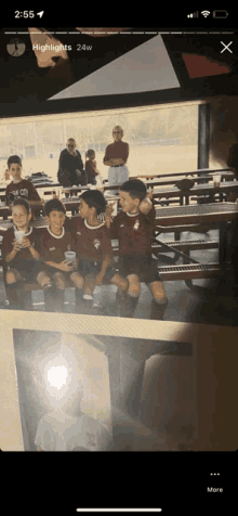 a phone screen shows a photo of a group of young boys sitting on a bench