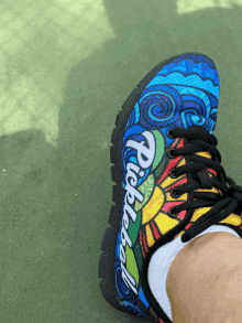 a person wearing a pair of colorful shoes with the word pebbleball written on the side