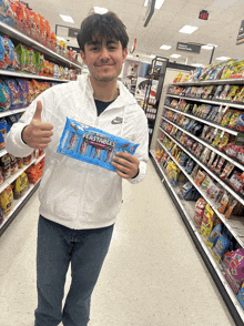 a man in a white nike jacket is holding a package of ferstables