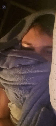 a person wrapped in a blue blanket with their face covered