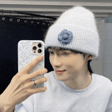 a person wearing a white beanie is taking a picture of themselves