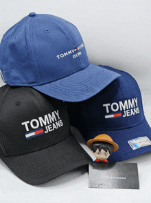 three tommy jeans hats are on a table