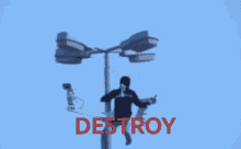 a man sitting on top of a pole with the word destroy written in red