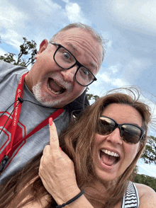 a man and a woman are posing for a picture and the man is wearing a lanyard that says ' coors light '