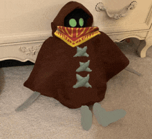 a stuffed animal with a hood and a scarf around its face