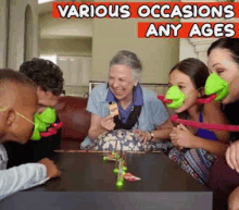 a group of people are sitting around a table playing a game with frogs on their faces .