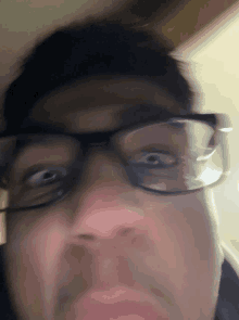 a close up of a man wearing glasses making a surprised face