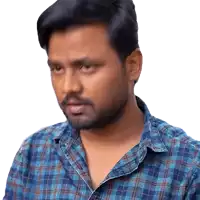 a man with a beard wearing a blue plaid shirt looks at the camera