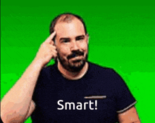 a man with a mustache is pointing his finger at his forehead with the words smart written on his shirt .