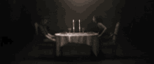 a blurry picture of two people sitting at a table with candles on it