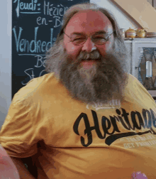 a man with a beard is wearing a yellow heritage shirt