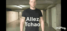 a man wearing a black shirt with the words allez tchao on it