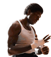 a man in a white tank top is wrapping his hands in white bandages