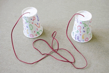 two paper cups with numbers on them are connected by red string