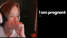 a person wearing headphones with the words " i am pregnant " on the bottom