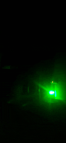 a green light is shining on a dark background